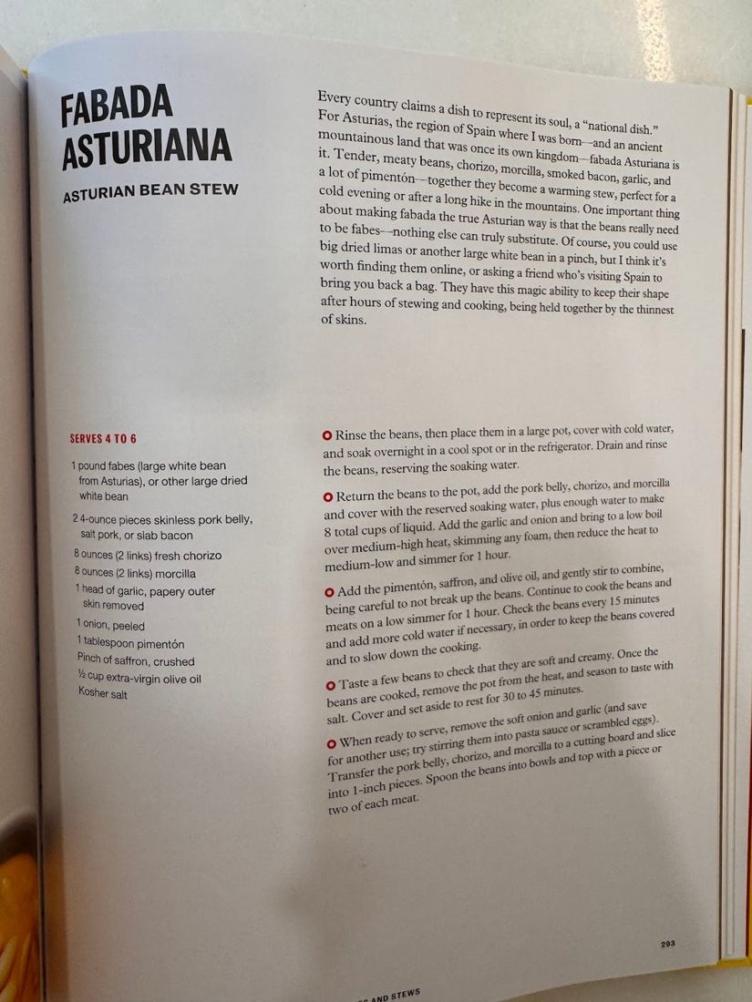 A cookbook page for Fabada Asturiana, photographed on a counter